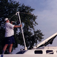 After attaching the hoist, mast, forward lowers and upper shrouds to the boat and aft lowers to the hoist, begin hoisting